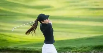 Femme frappant la balle hors du bunker