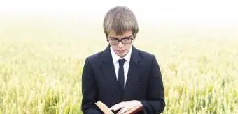 menino lendo poema de livro em campo