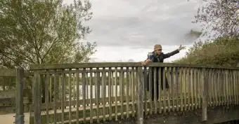 mulher espalhando cinzas cremadas da ponte na água