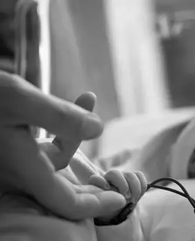 אבא מחזיק תינוק גוסס